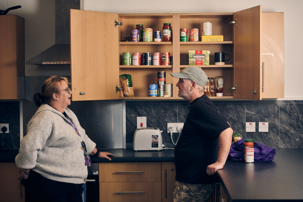 staff member and service user talking in kitchen