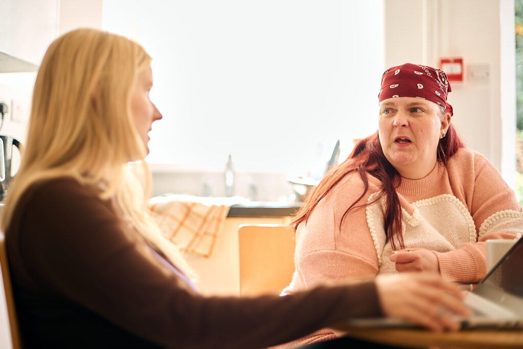 Two women sitting at a kitchen table, support