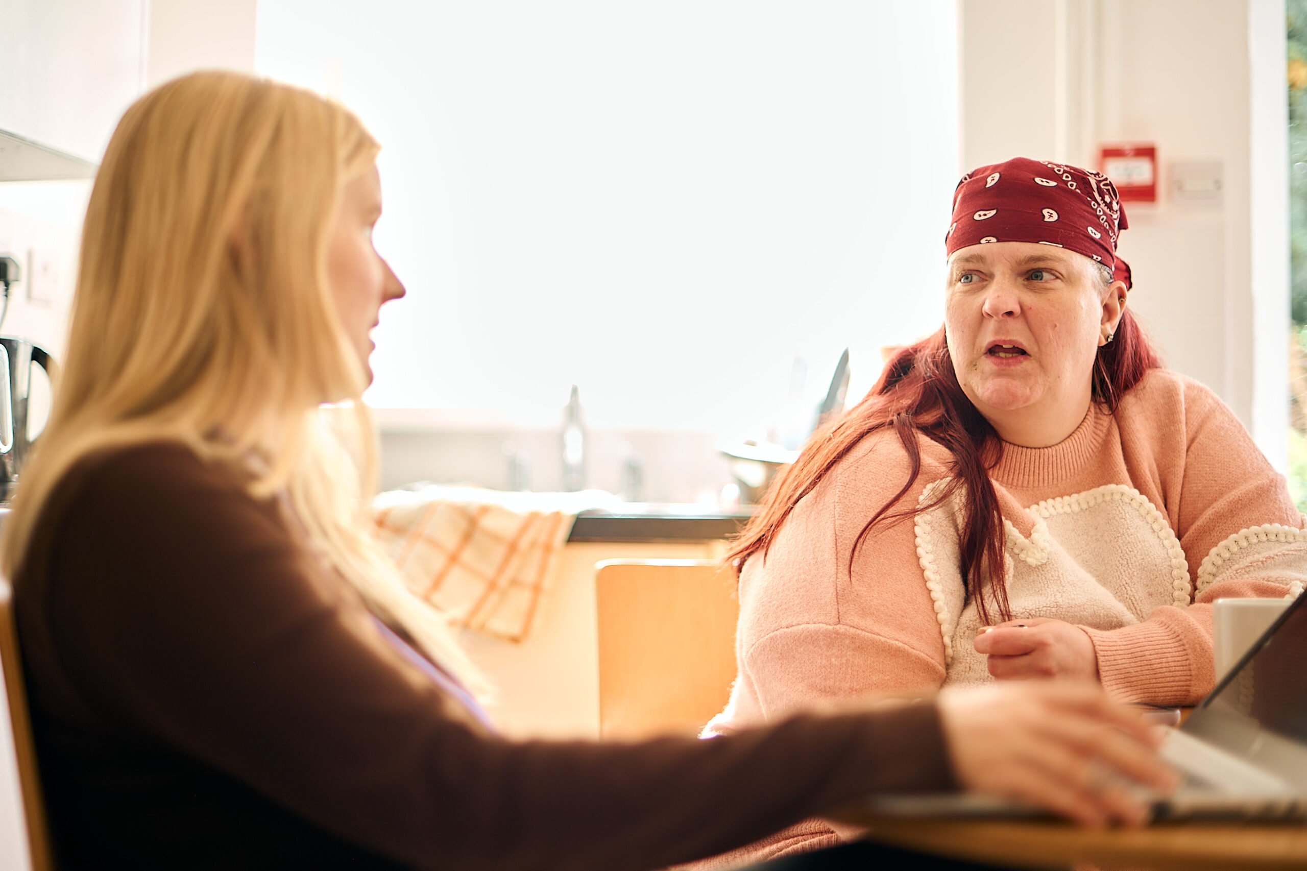 Two women sitting at a kitchen table, support