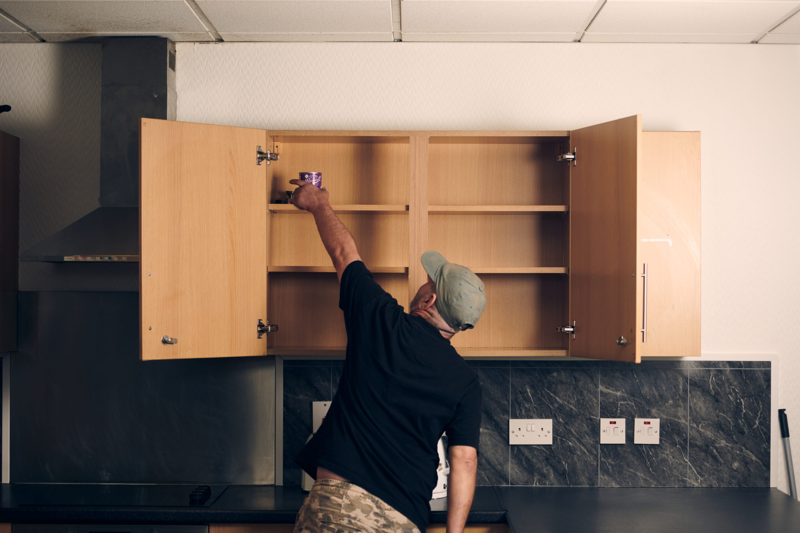 Windor reaching into full kitchen cupboards