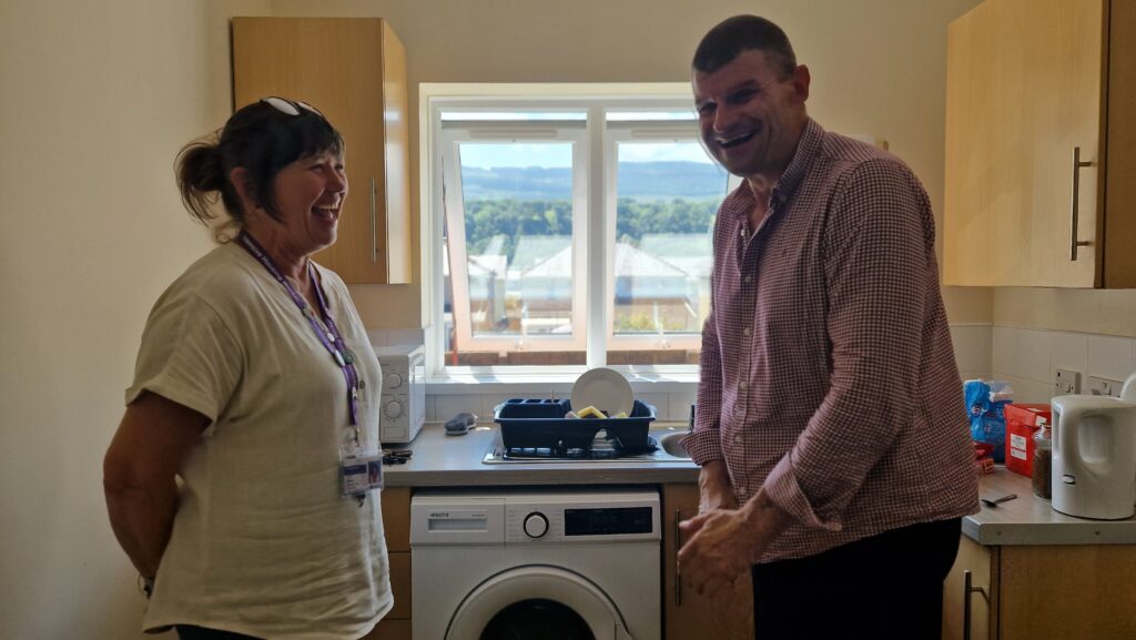 Andre and Nic stand in a kitchen in Glyneath - The Wallich homelessness prevention Neath Port Talbot