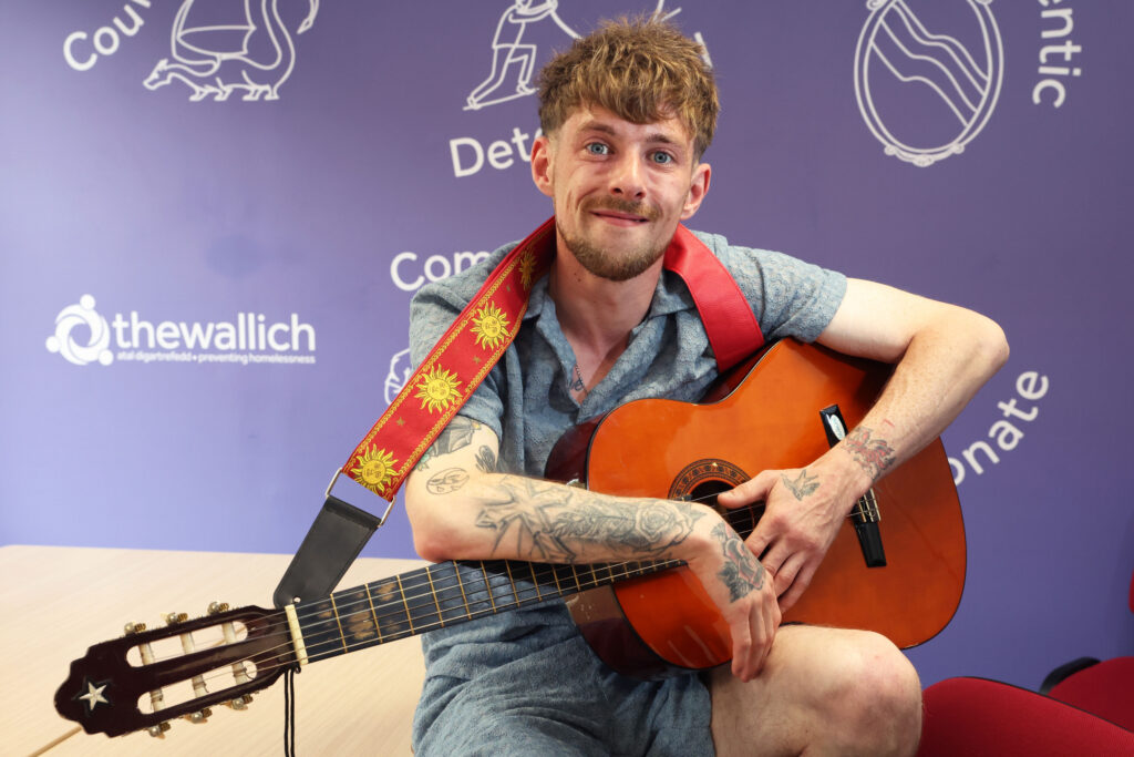 Service user holding a guitar