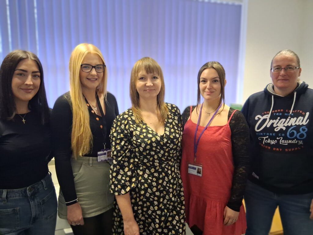 Team of 5 women stand in a row - Housing First team